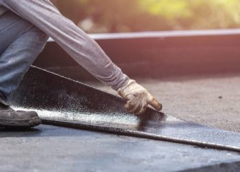 Asia worker installing tar foil on the rooftop of building. Waterproof system by gas and fire torching